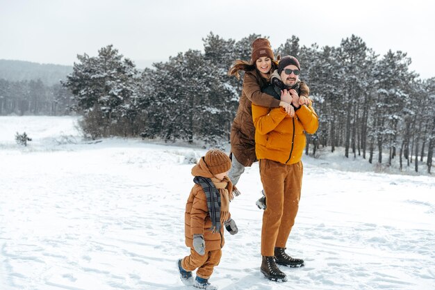 Szczęśliwa rodzina spacerująca zimą na świeżym powietrzu w śniegu