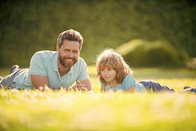 Szczęśliwa rodzina tatusia i syna dziecka relaksuje się w letnim parku zielona trawa dzień ojca