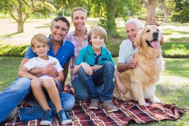 Zdjęcie szczęśliwa rodzina uśmiecha się do kamery z psem