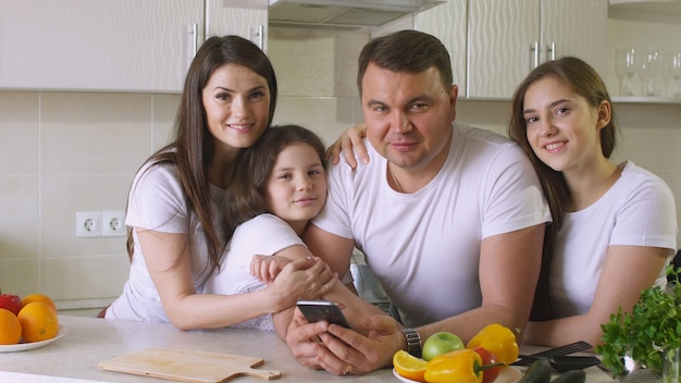 Szczęśliwa rodzina w domu w kuchni, uśmiech i patrząc na kamery