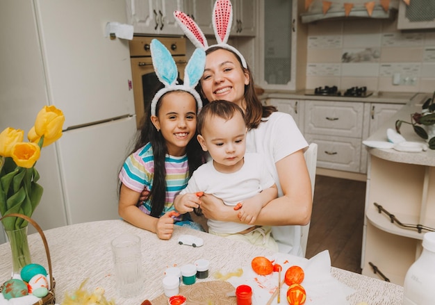 Zdjęcie szczęśliwa rodzina w kuchni. mama i dzieci w strojach kucharza w kuchni. mama i dzieci przygotowują ciasto, pieką ciasteczka