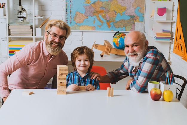 Szczęśliwa rodzina wielopokoleniowa grająca razem w jenga w domowych grach ojcowskich dla rodziny