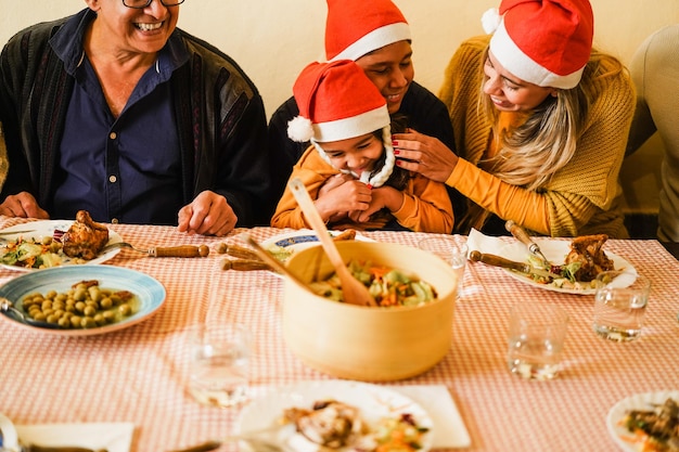 Szczęśliwa rodzina z Ameryki Łacińskiej dobrze się bawi, jedząc razem w czasie świąt Bożego Narodzenia. Skup się na ustach dziadka