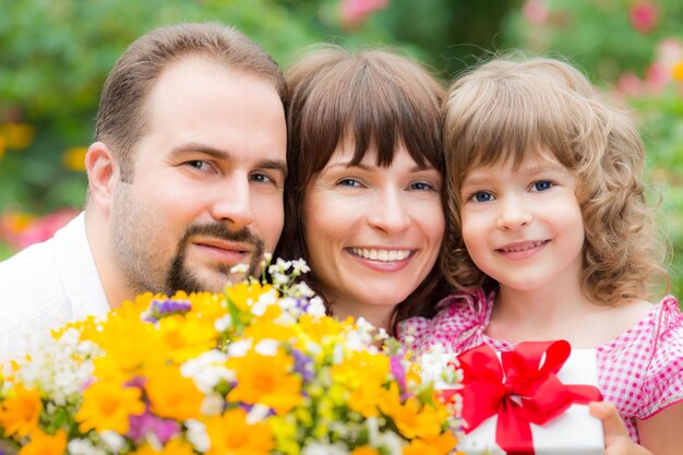 Szczęśliwa rodzina z bukietem kwiatów na zielonym tle Koncepcja wakacji wiosennych Dzień matki