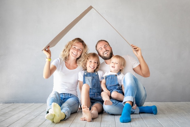 Zdjęcie szczęśliwa rodzina z dwójką dzieci bawiące się w nowym domu
