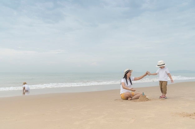 szczęśliwa rodzina z dwójką dzieci na plaży,