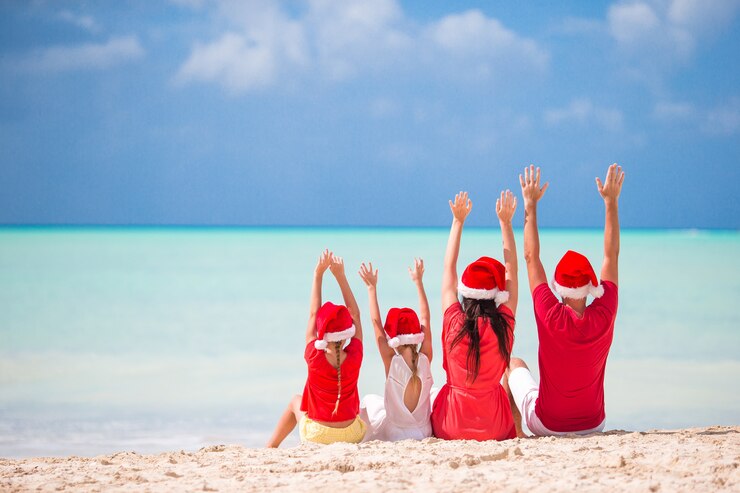 Zdjęcie szczęśliwa rodzina z dwójką dzieci w santa hat na wakacjach