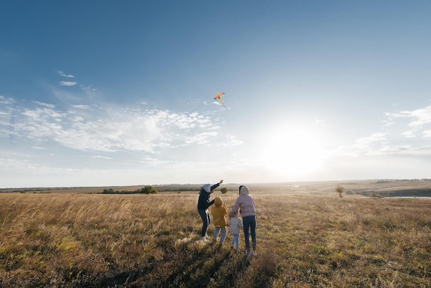 Szczęśliwa rodzina z dziećmi leci latawcem i spędza razem czas na świeżym powietrzu w rezerwacie przyrody Szczęśliwe dzieciństwo i rodzinne wakacje Wolność i przestrzeń