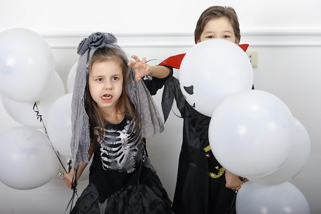 Szczęśliwa rodzina z dziećmi w strojach czarownicy i wampira w domu w wakacyjny Halloween