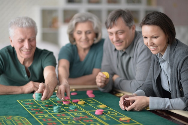 Szczęśliwa Rodzina Z Parą Seniorów Grającą Z żetonami W Kasynie