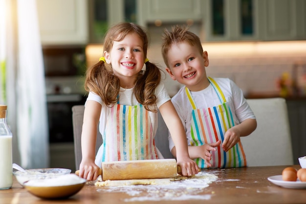 Szczęśliwa rodzina zabawne dzieci przygotowują ciasto do pieczenia ciasteczek w kuchni