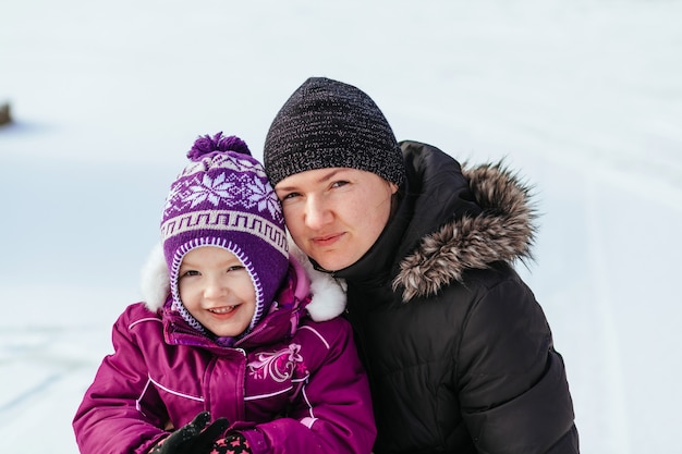 Szczęśliwa rodziny matka i dziewczynki córka bawić się śmiać się w zimie outdoors