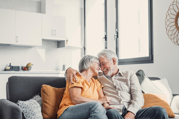 Szczęśliwa roześmiana starsza para małżeńska rozmawia śmiejąc się stojąc we wnętrzu domu razem przytulając się z miłością ciesząc się bliskimi związkami zaufanie wsparcie opieka uczucie radość czułośćxA