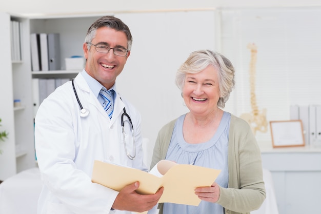 Szczęśliwa samiec lekarka i kobieta pacjent z raportami