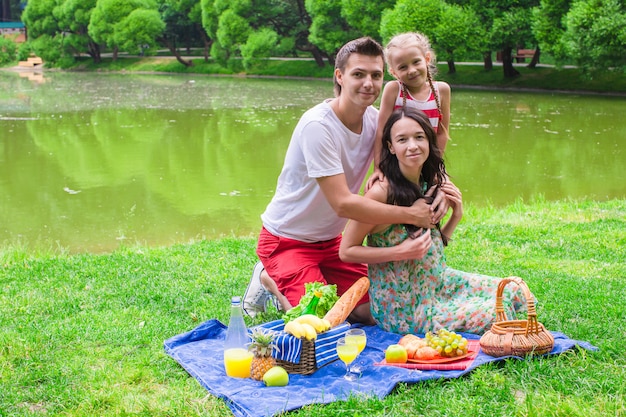 Szczęśliwa śliczna rodzina trzy piknikowa plenerowa