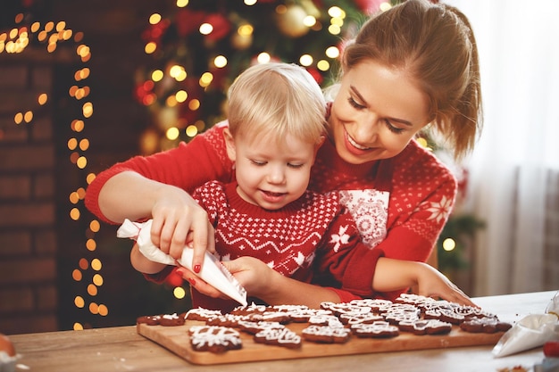 Szczęśliwa śmieszna mama i dziecko pieczą świąteczne ciasteczka