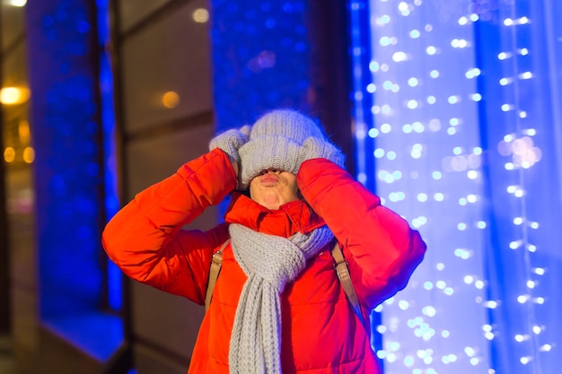 Szczęśliwa śmieszna Młoda Kobieta Z Zimowymi Ubraniami W Tle Wieczorem światła Miasta Oświetlenie Boże Narodzenie