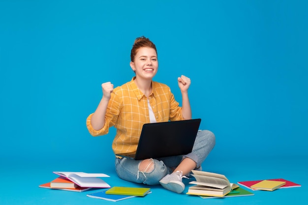 Zdjęcie szczęśliwa studentka z laptopem świętująca sukces