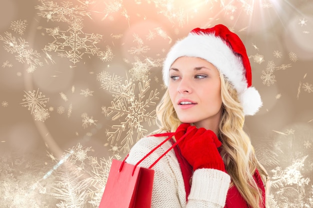 Szczęśliwa świąteczna blondynka z torbą na zakupy przeciw kremowemu płatkowi śniegu wzorcowemu projektowi