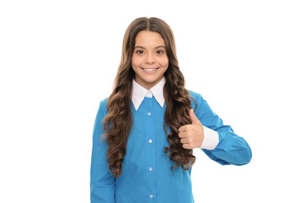 Szczęśliwa twarz nastoletniej dziewczyny z długimi kręconymi włosami na białym tle pokazuje kciuk w górę włosów