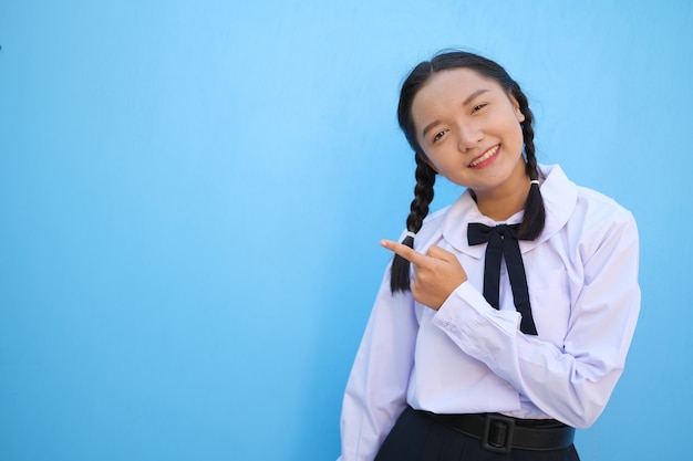 Szczęśliwa uczennica na niebieskim tle Azjatycka dziewczyna