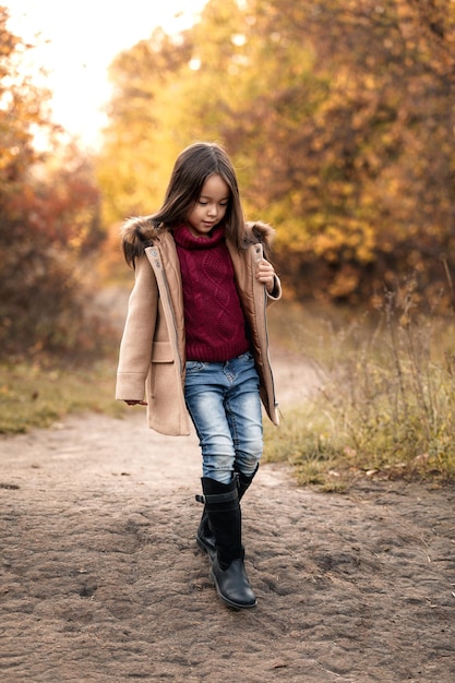 Szczęśliwa urocza dziewczynka biega w jesiennym parku