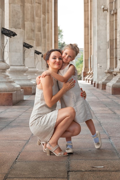 Szczęśliwa Uśmiechnięta Mama Z Córką Dziecko W Słoneczny Letni Dzień Matka I Dziewczynka Spacerują Po Mieście W łuku