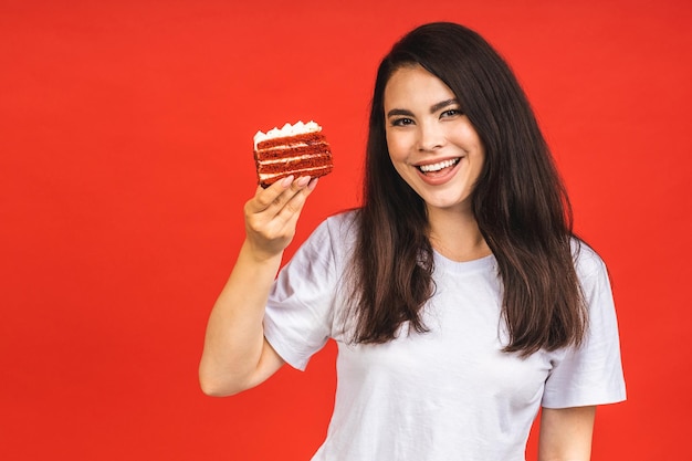 Szczęśliwa Uśmiechnięta Młoda Kobieta Je Tort Na Białym Tle Na Czerwonym Tle Brunetka Dama Trzymająca Tort Urodzinowy