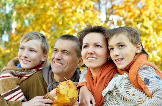 Szczęśliwa uśmiechnięta rodzina relaksuje się w jesiennym parku