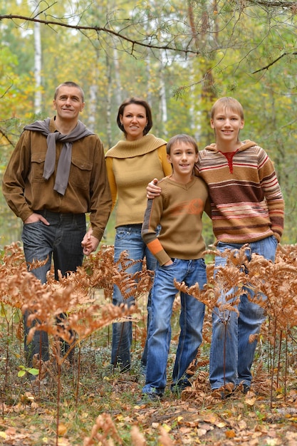 Szczęśliwa uśmiechnięta rodzina w jesiennym lesie