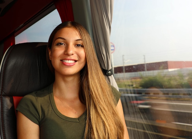 Szczęśliwa wesoła piękna podróżnik kobieta w autobusie patrząc na kamery. Koncepcja podmiejskich transportu publicznego.