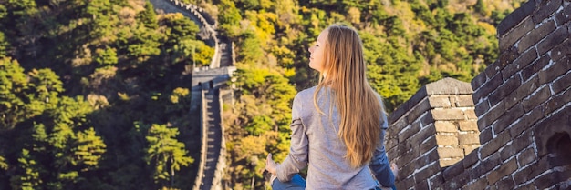 Szczęśliwa wesoła radosna turystka przy wielkim murze chińskim medytuje podczas wakacyjnej wycieczki w Azji dziewczyna
