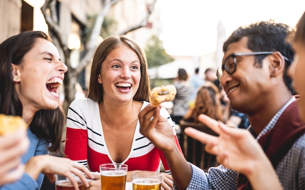Szczęśliwa ząb uśmiechnięta młoda kobieta w browarze z pokoleniem przyjaciół z ludzi bawiących się w pubie wesoły i pozytywny obraz spotkania grupy studentów