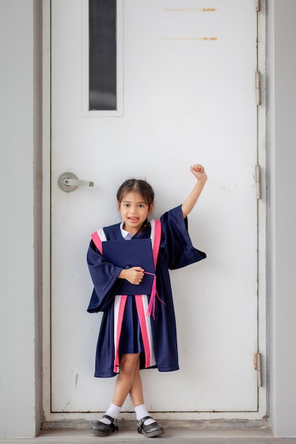 Szczęśliwe azjatyckie dziewczyny w sukniach ukończenia szkoły w dniu ukończenia szkoły Koncepcja ukończenia szkoły z kopią spacex9