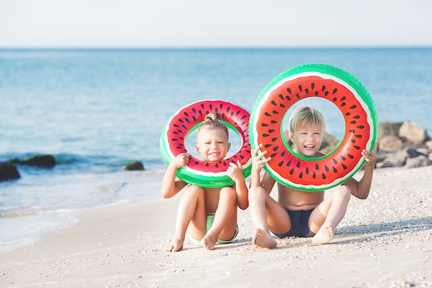 Szczęśliwe dzieci bawiące się na plaży. Aktywne dzieci na tle lata.