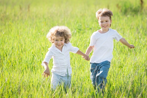 Szczęśliwe dzieci bawiące się na wiosennym polu