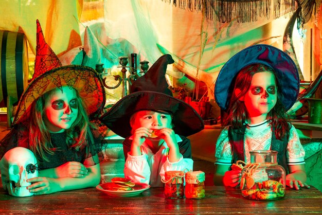 Szczęśliwe dzieci na imprezie halloweenowej grupowe dzieci, takie jak zombie lub wiedźma, gotowe na sztuczkę lub smakołyk calaverita tr...