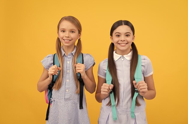 Szczęśliwe dzieci wracają do szkoły w Dzień Wiedzy 1 września żółte tło Dzieciństwo