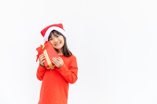 Szczęśliwe dziecko azjatyckie w Santa czerwony kapelusz gospodarstwa prezenty świąteczne. Boże Narodzenie time.on białym tle.