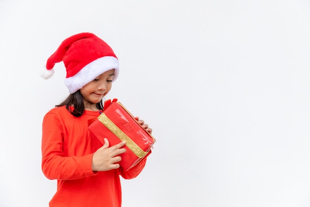 Szczęśliwe dziecko azjatyckie w Santa czerwony kapelusz gospodarstwa prezenty świąteczne. Boże Narodzenie time.on białym tle.