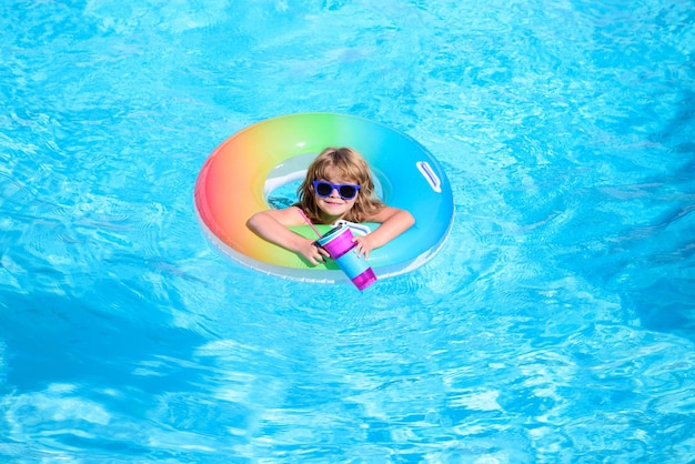 Szczęśliwe dziecko bawiące się kolorowym kółkiem do pływania w basenie w letni dzień zabawki wodne dla dzieci dzieci p
