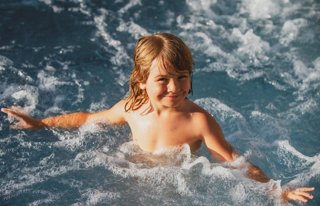 Szczęśliwe dziecko bawiące się w basenie. Koncepcja wakacji letnich. Wanna z hydromasażem. Letnie wakacje dla dzieci.