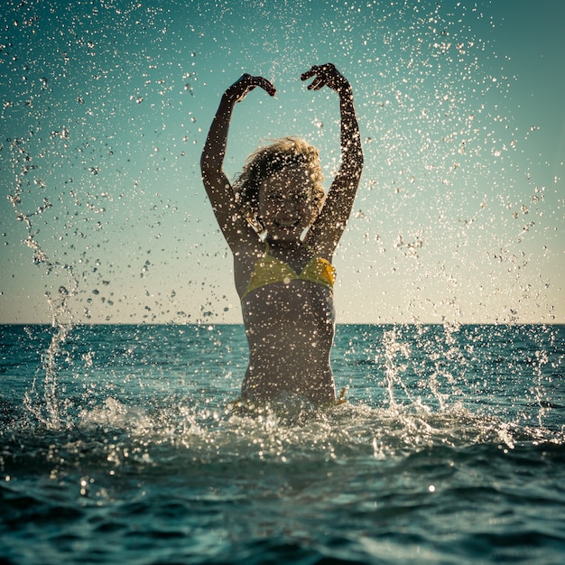 Szczęśliwe dziecko bawiące się w morzu. Dziecko zabawy na wakacjach. Koncepcja zdrowego, aktywnego stylu życia