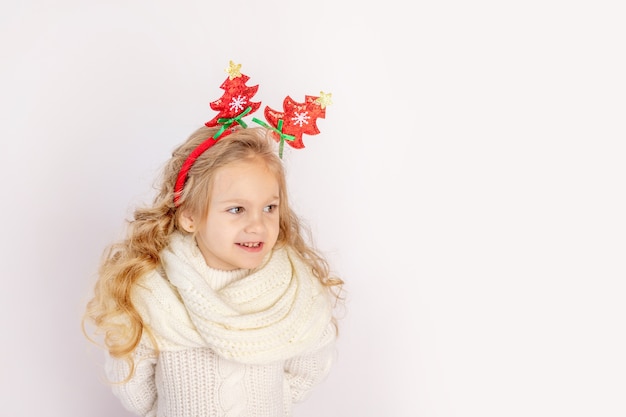 Szczęśliwe dziecko dziewczyna w Boże Narodzenie sweter i pałąk na białym tle