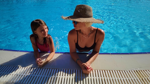 Szczęśliwe dziecko i kobieta grając w basenie. Koncepcja wakacji letnich.