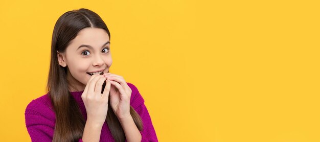 Szczęśliwe dziecko kochanie cieszyć się jedzeniem smacznej czekoladowej tabliczki żółte tło przekąska Poziomy plakat izolowanego dziecka twarz baner nagłówek kopia przestrzeń