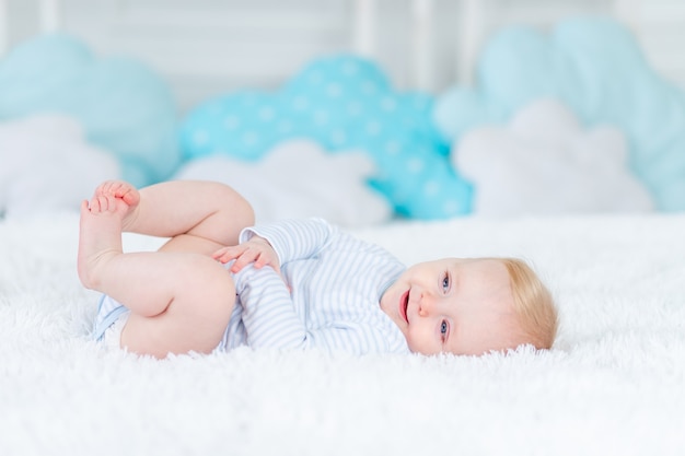 Szczęśliwe Dziecko Na łóżku Na Plecach Uśmiechnięty Chłopczyk Blondyn W Wieku Sześciu Miesięcy