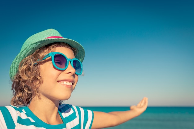 Szczęśliwe dziecko na plaży Dziecko bawiące się na wakacjach Koncepcja zdrowego aktywnego stylu życia