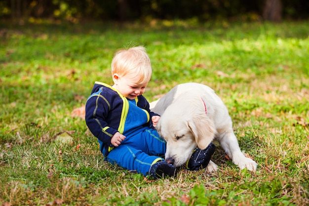 Szczęśliwe dziecko na trawniku ze swoim psem