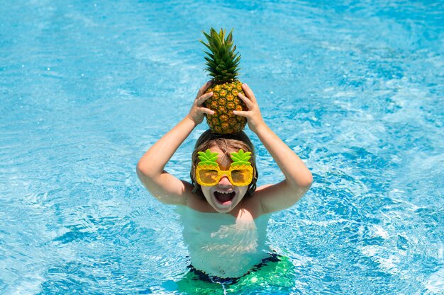 Szczęśliwe dziecko w basenie w letni dzień Zabawa dzieci w tropikalnym kurorcie Śmieszne owoce ananasa dla dzieci Letnie wakacje